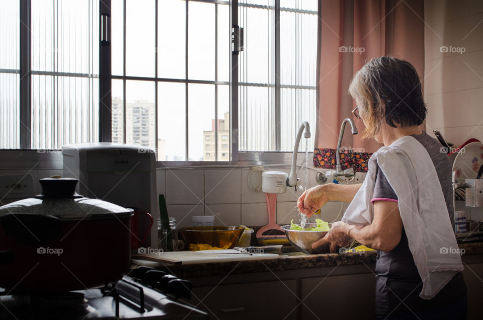 A woman sanitizing vegetables to make a delicious salad. A daily habit to take care of health.