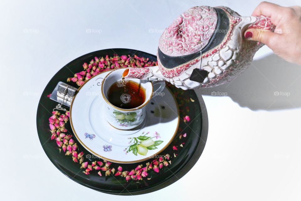 Woman pouring black tea in cup