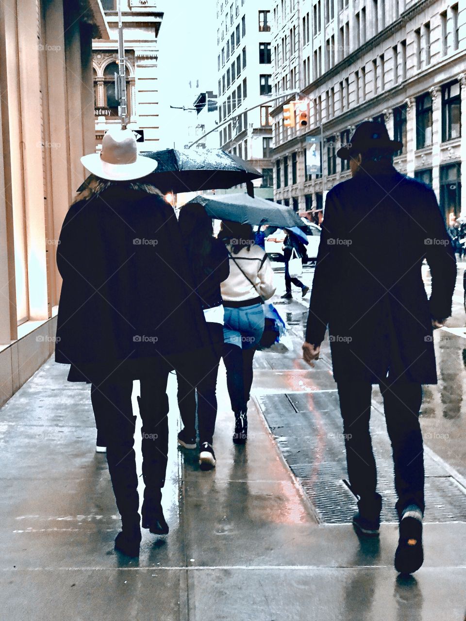 Couple wearing similar hats walkig down street in SOHO New York City 