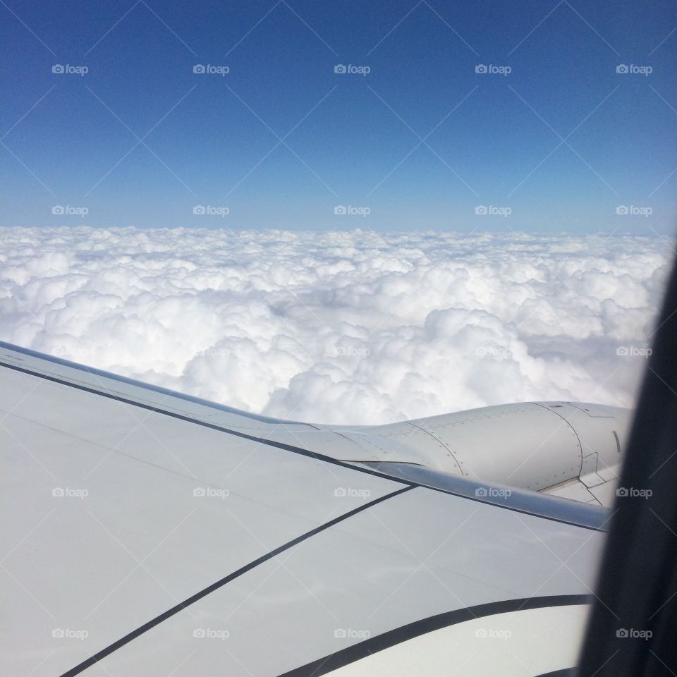 View from the wing. A shot out an airplane window overlooking the wing towards the clouds