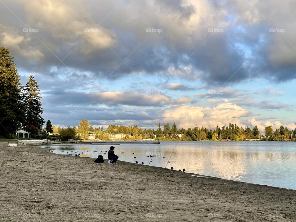 Autumn landscape at the lake with clouds. Fall fishing 