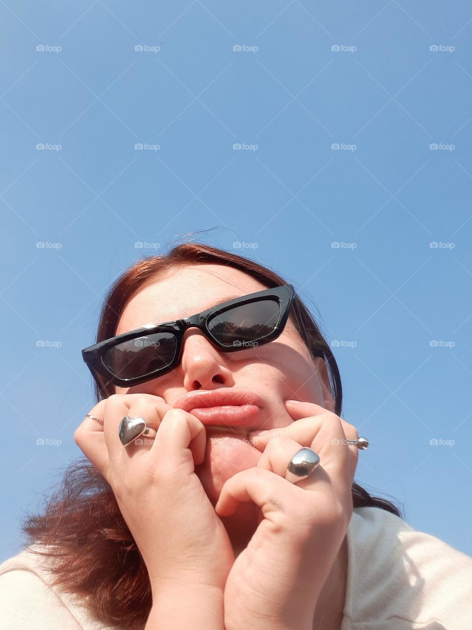 comedic female portrait of a light-skinned girl in sunglasses who scrunches her face
