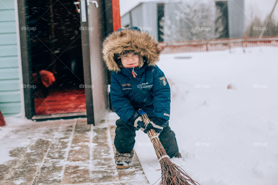 boy sweeping snow