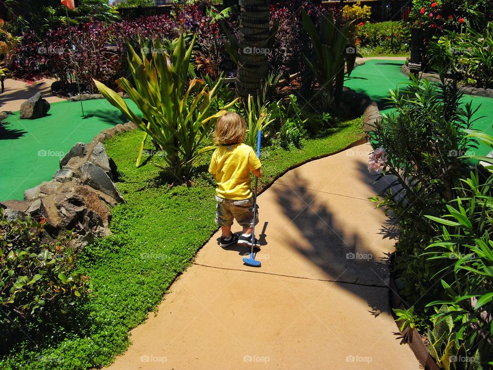 Toddler Playing Miniature Golf
