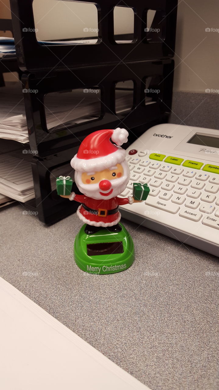 Dancing Santa brightens up an office desk for the holidays.