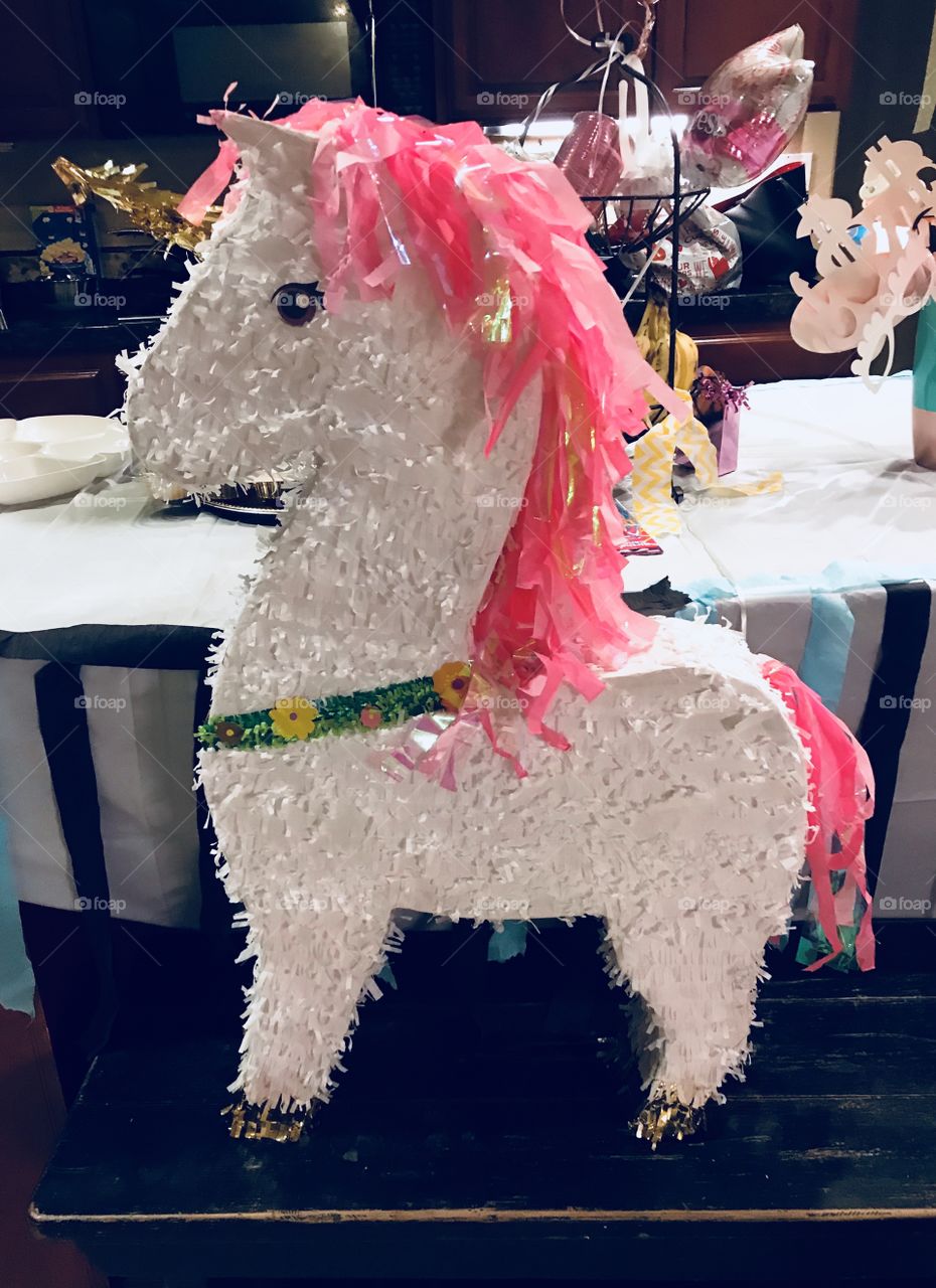 A beautiful and colorful bright pink and white unicorn party piñata on display, celebrating a sweet 16 birthday. USA, America 