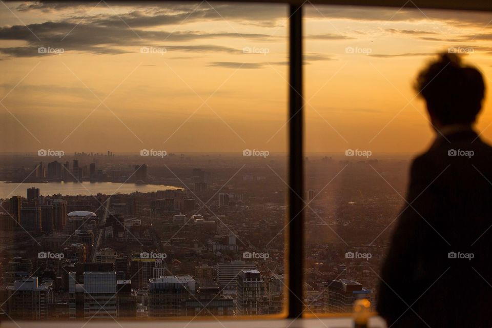Glowing shot of a young man overlooking a city at sunset