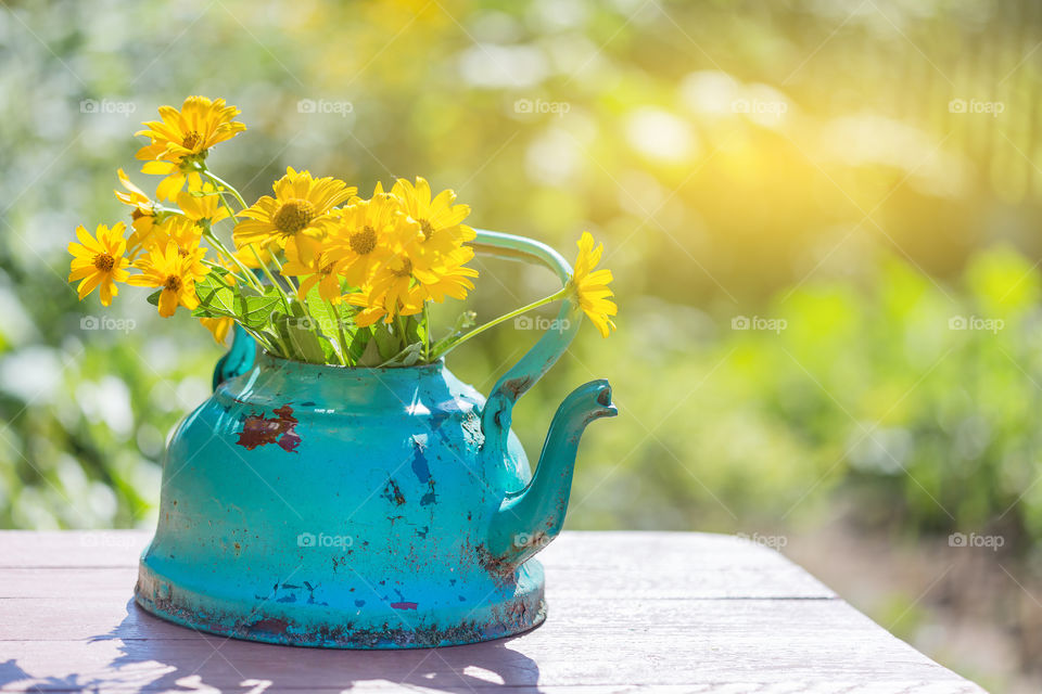 Antique turquoise teapot with wild summer flowers bouquet