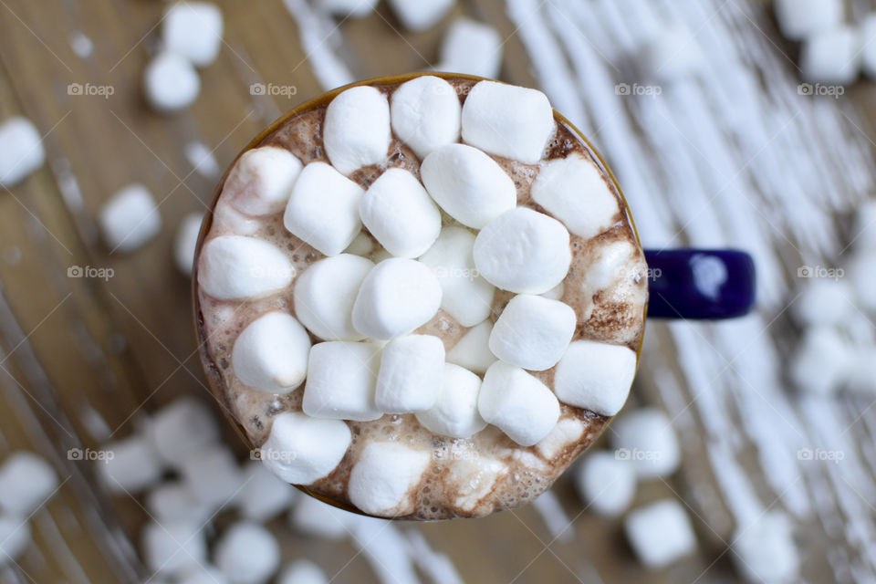 A cup of hot cocoa topped with extra marshmallows 