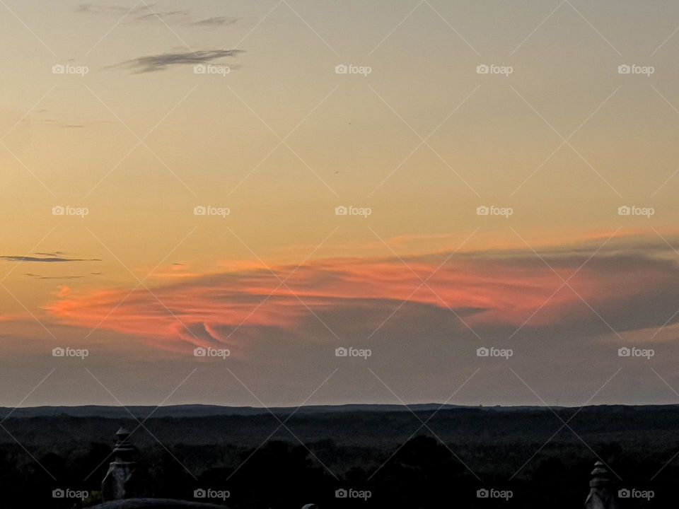 A cloud illuminated as the sun sets lighting up the sky in beautiful hues on Choctaw Ridge.