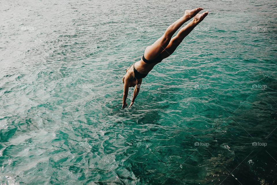 Girl diving into turquoise waters.