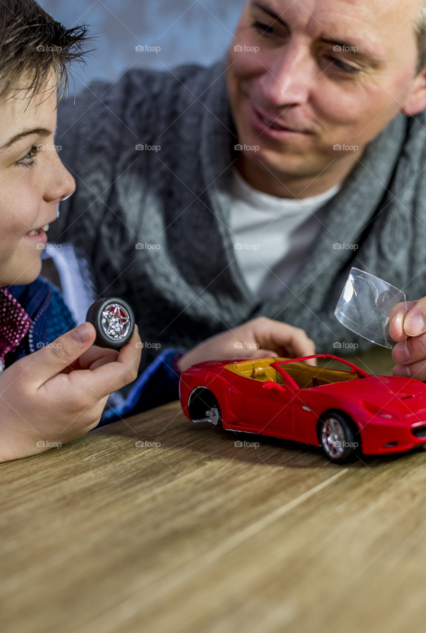father and son building a model car togheter