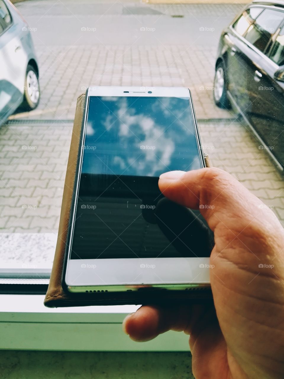 hand holding smartphone on street