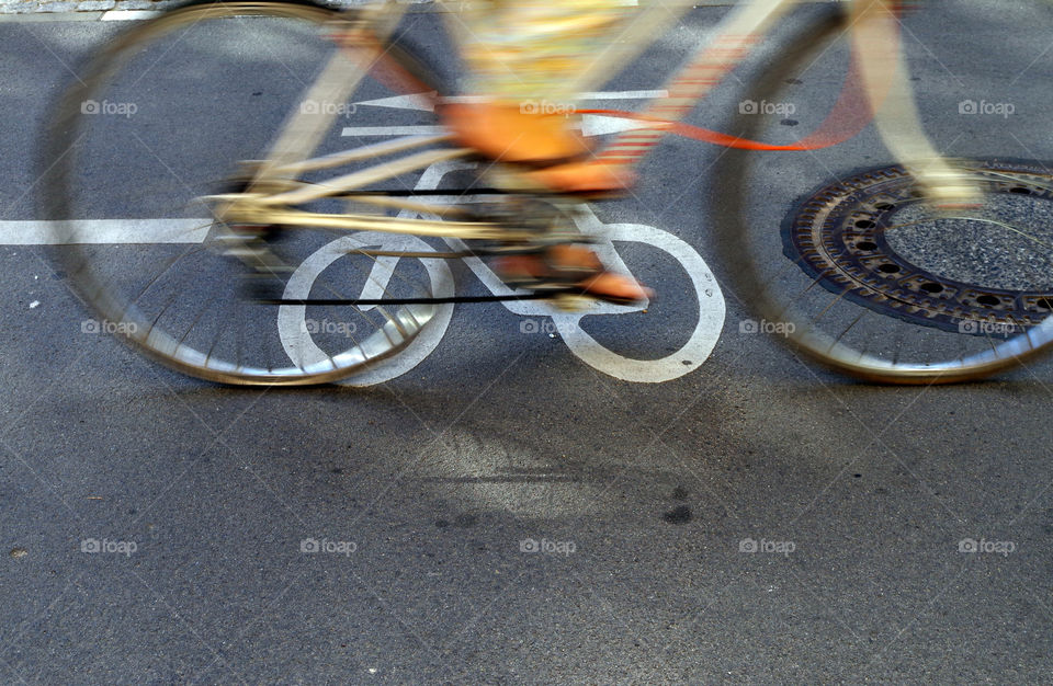 High angle view of blurred motion of cyclist on bikeway in city.