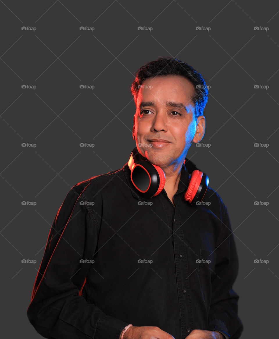 Indian man with wireless Bluetooth headphones