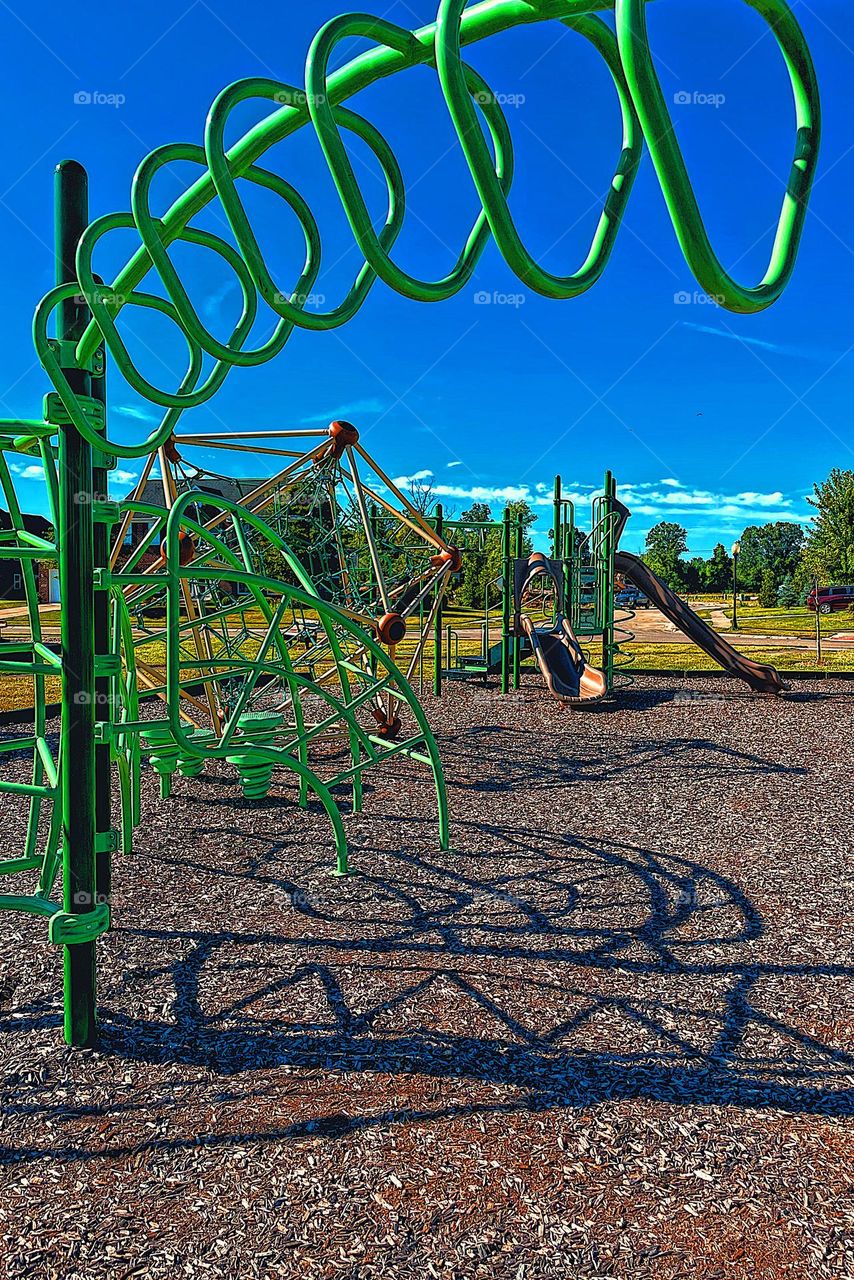 Metal triangular climbing equipment at the park, climbing equipment at the park, playground equipment in the summertime, shadows and metal at the park, fun at the park, fun with kids, playing outdoors 