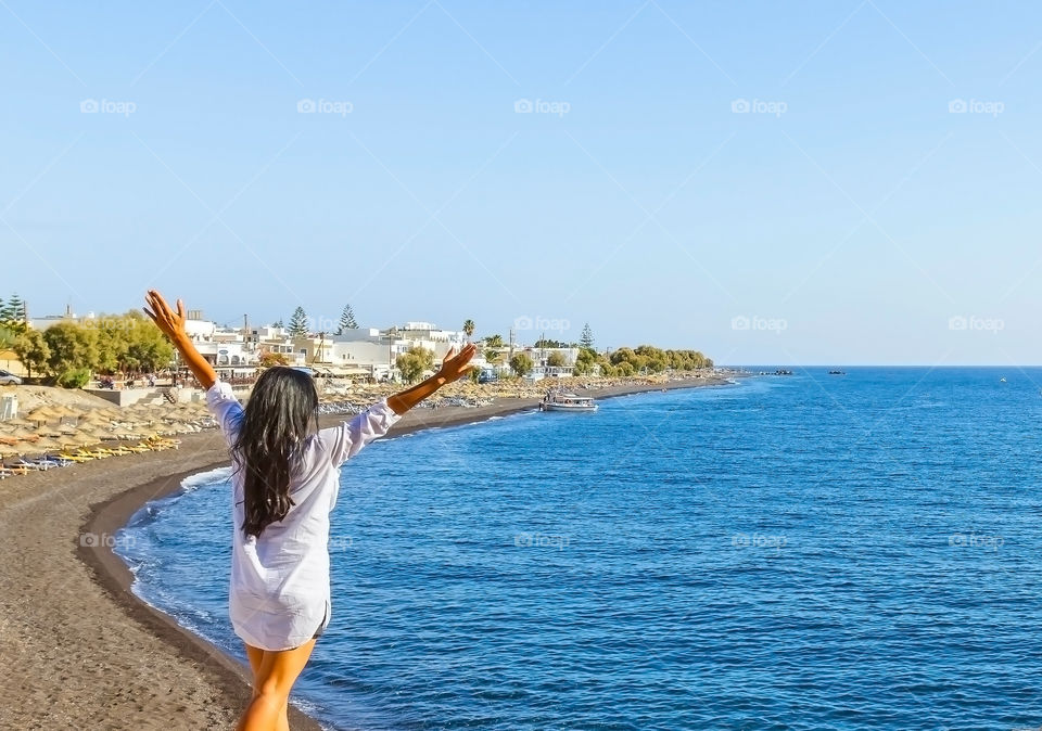 Rear view of a woman standing near the coast at beach