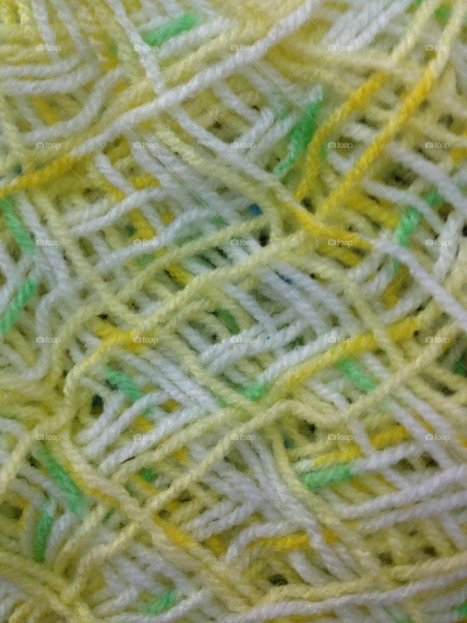 Close up of yarn with colours of yellow, green and white.