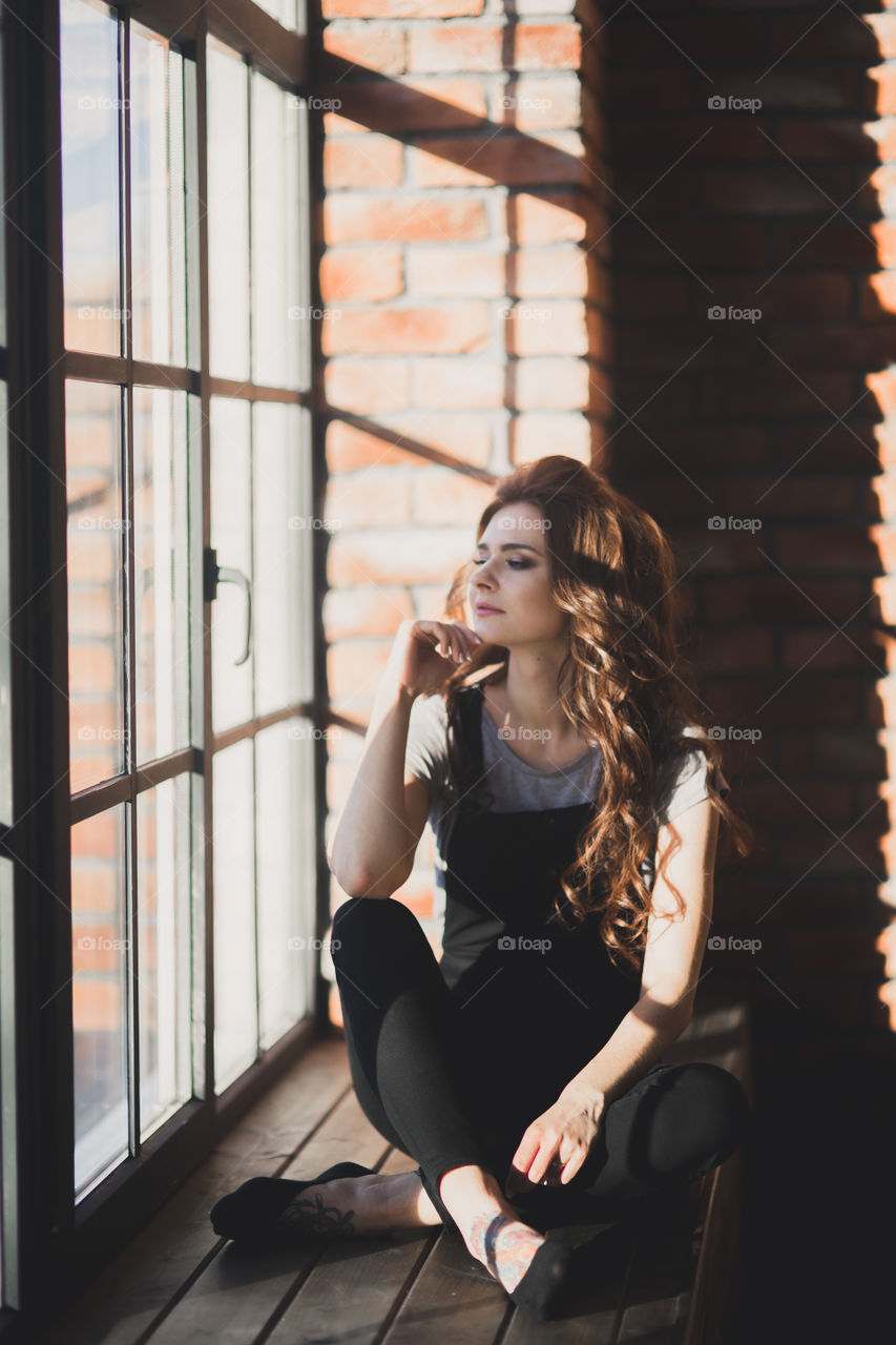 Portrait of young beautiful woman near window