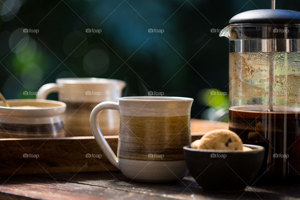 close up coffee mug with filter coffee on tray outside