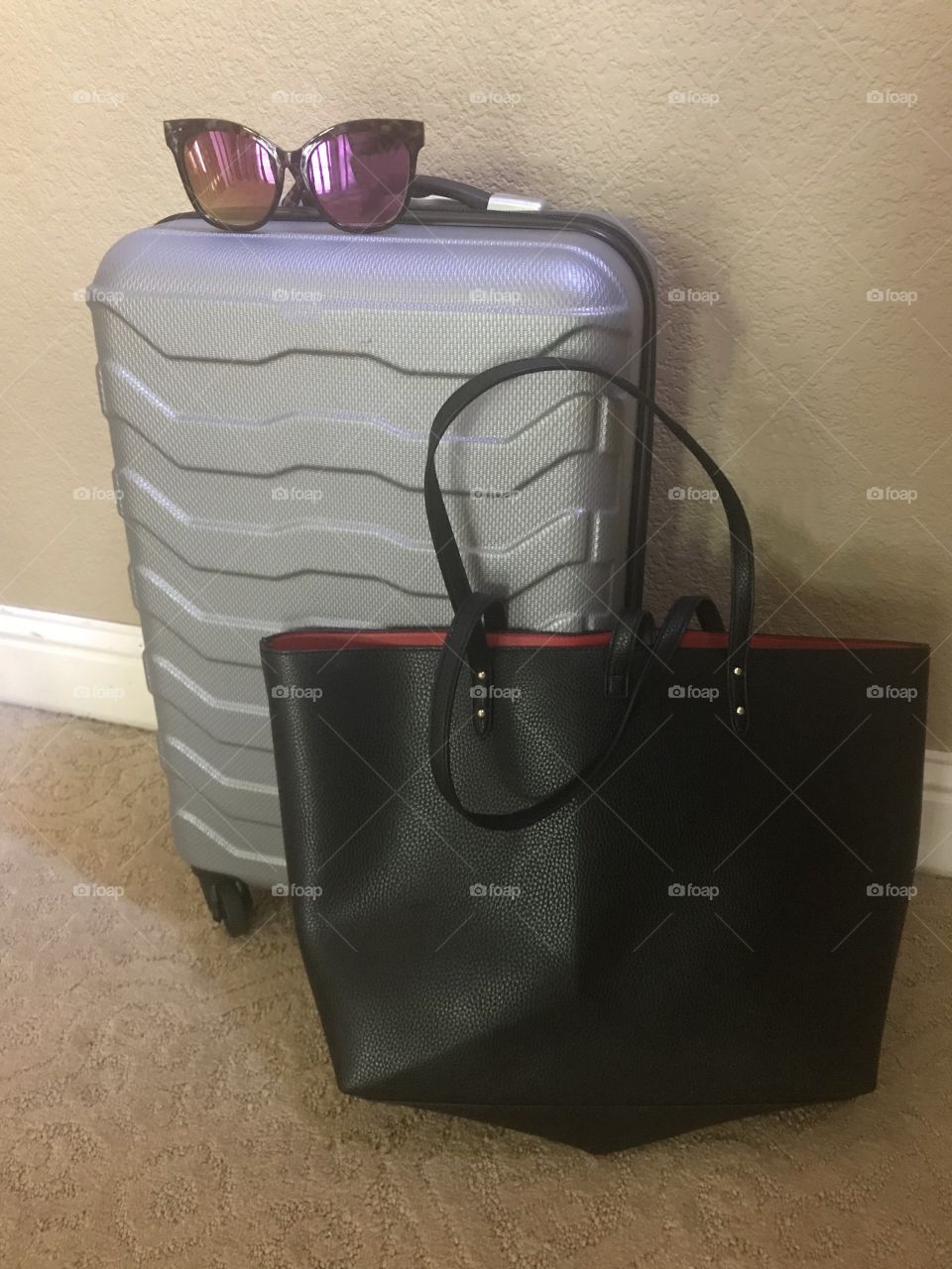 Luggage - bags are packed for vacation with silver suitcase, purse and sunglasses on top . 