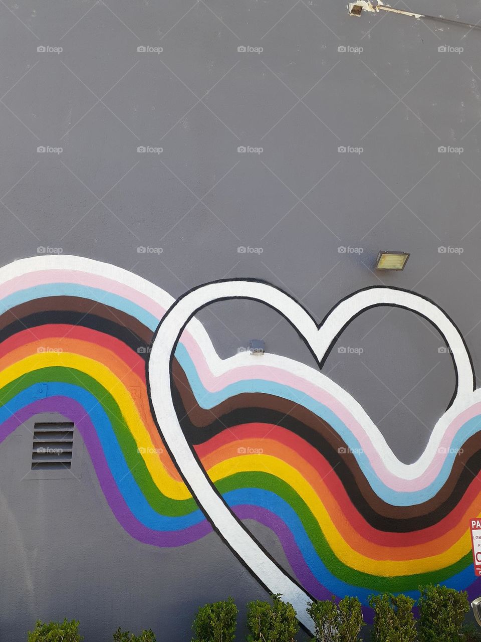 A mural depicting a rainbow flowing through a heart on the side of a building in downtown Orlando.
