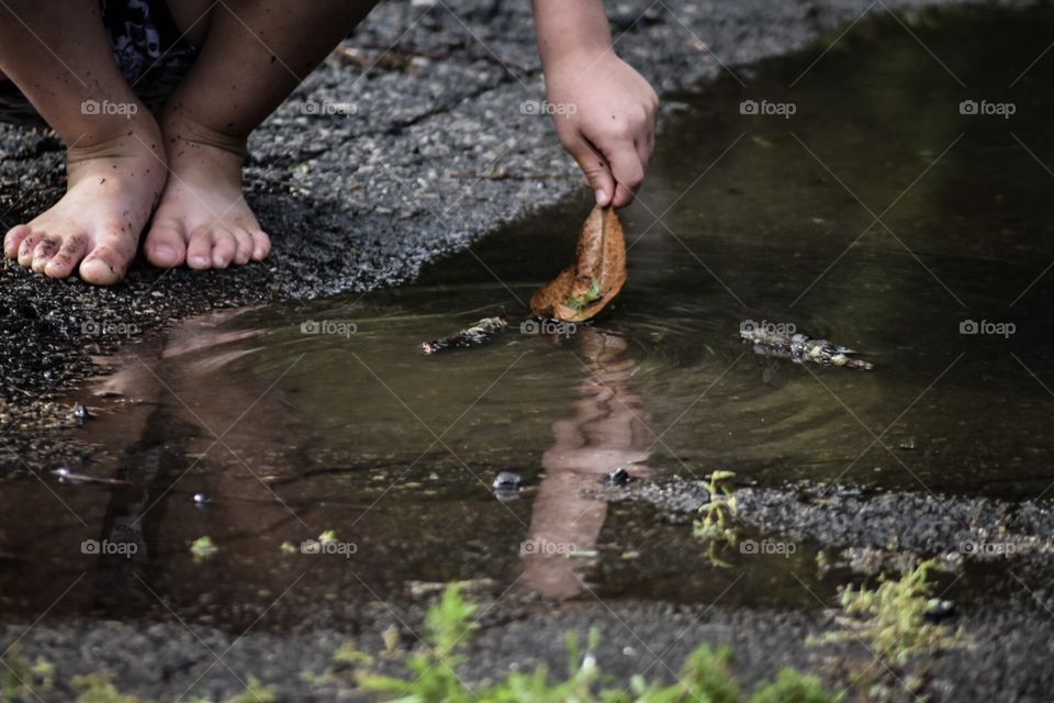 Little boy playing in a puddle