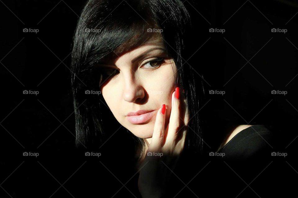 Portrait of young woman with red nail varnish