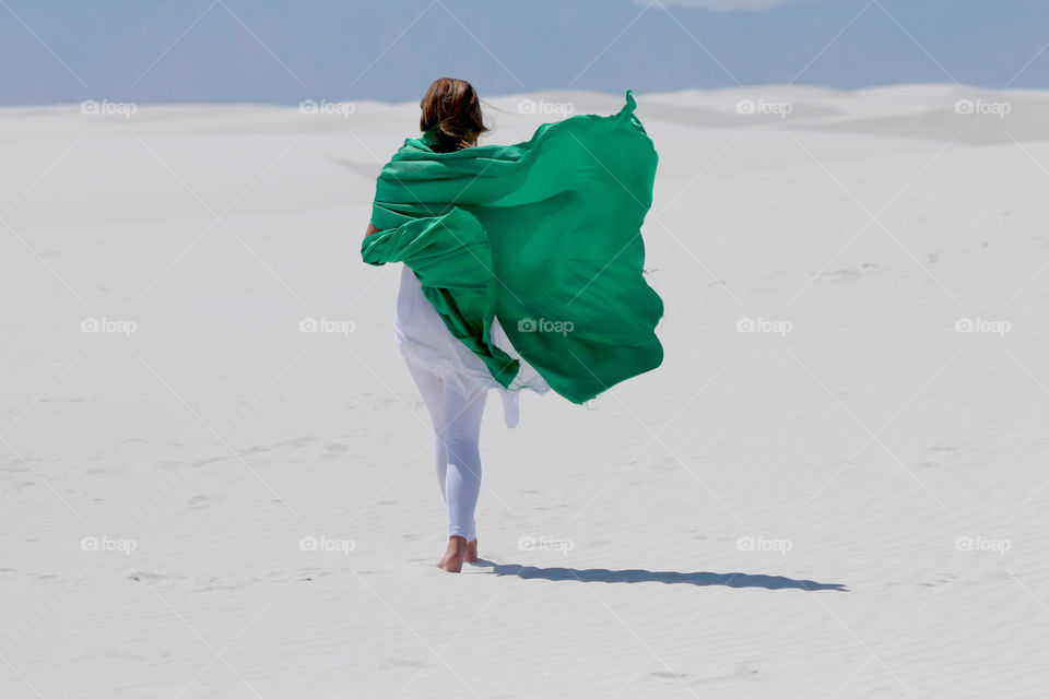 Rear view of a women walking on white sand
