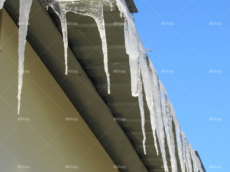 ice icicles on the cornice in the sun, harbingers of spring