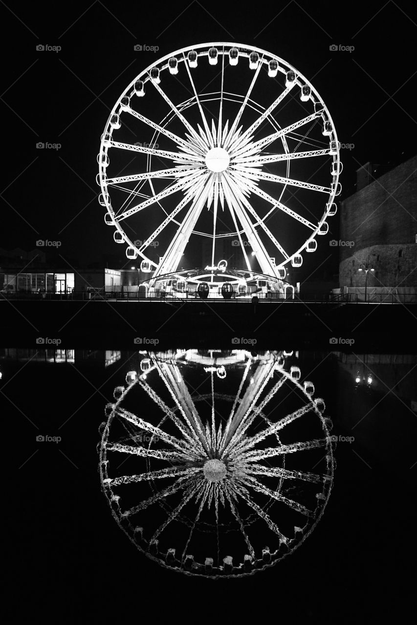 Night shot of a Ferris Wheel reflected in the water old town Gdańsk 