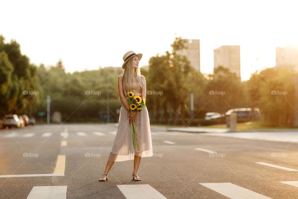 Stylish Caucasian woman with blonde hair wearing casual clothing at summer 