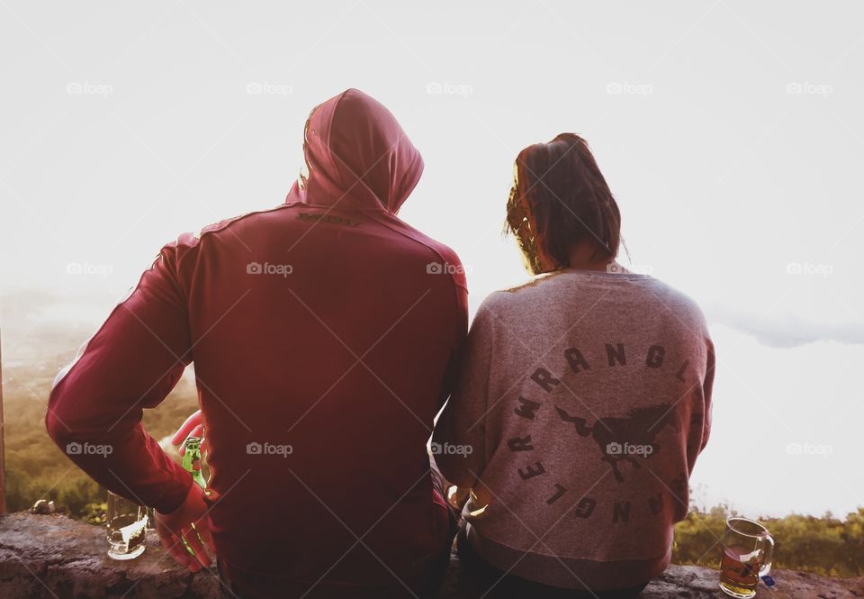 Young lover are sitting to see beautiful sunrise at Volcano, Indonesia 