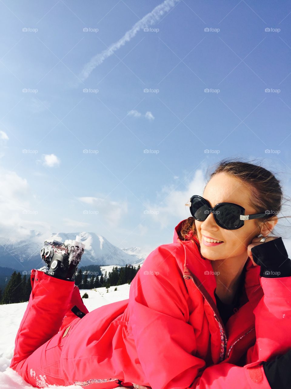 Smiling woman lying on snow