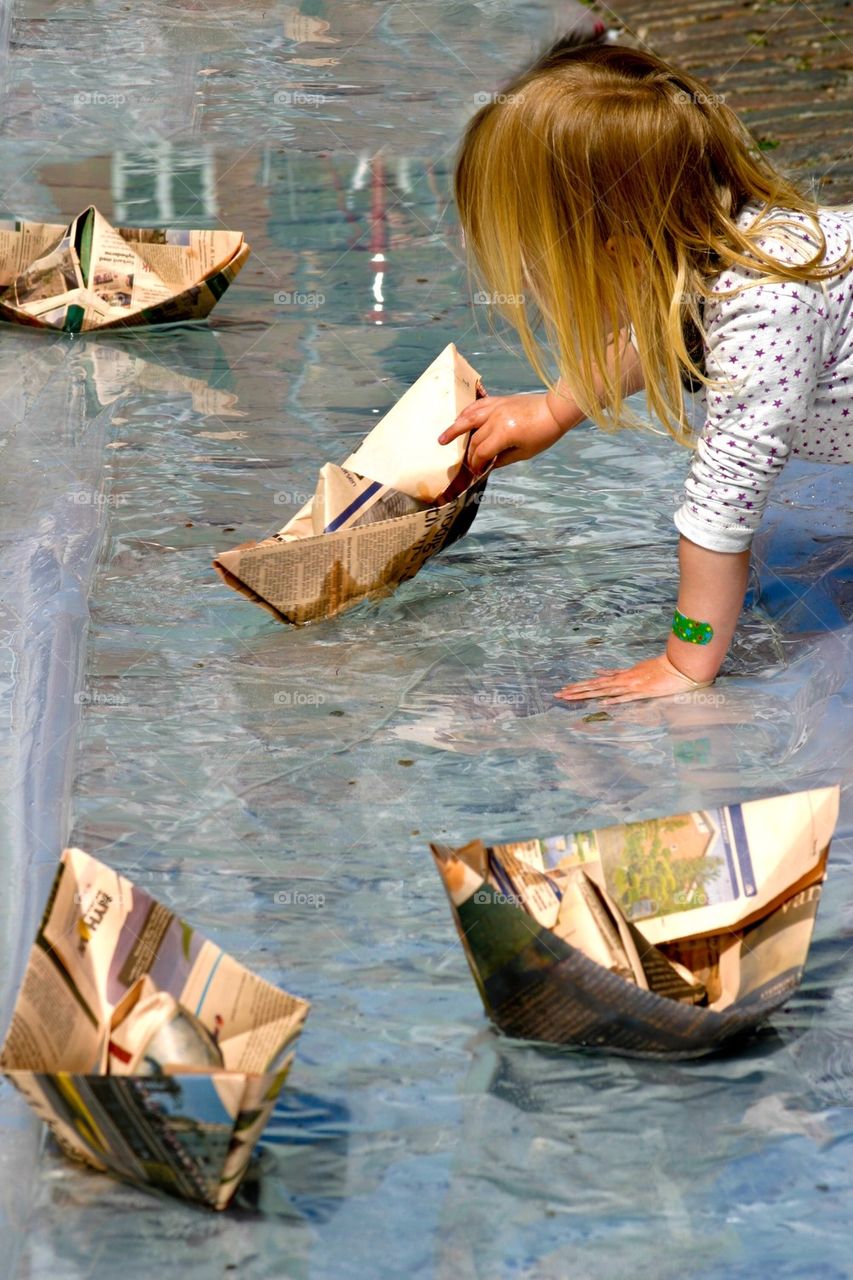 Girl playing with paper boats