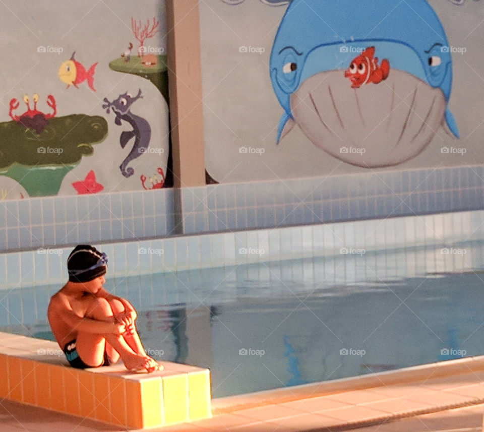 Child on the edge of the pool waiting for the start of the lesson