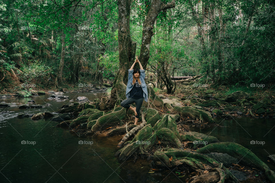 Girl doing yoga in the forest pond