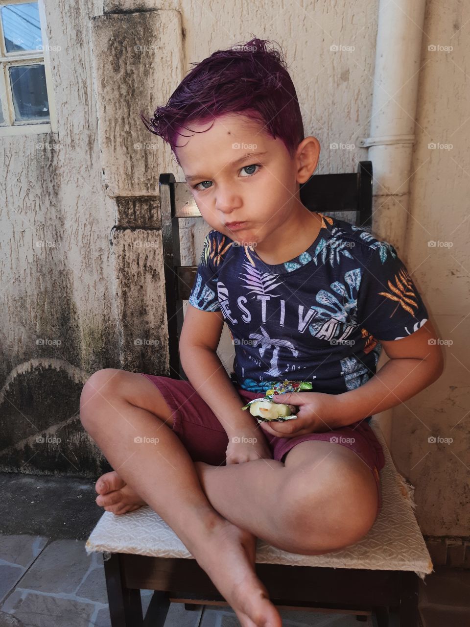 child with purple hair with blue eye making face