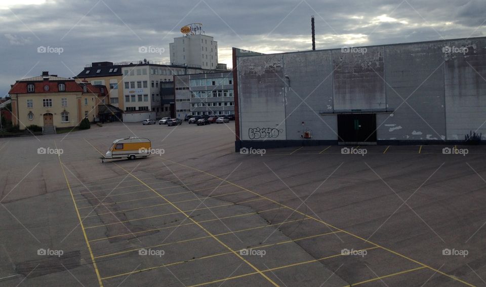 Yellow caravan in empty parking space