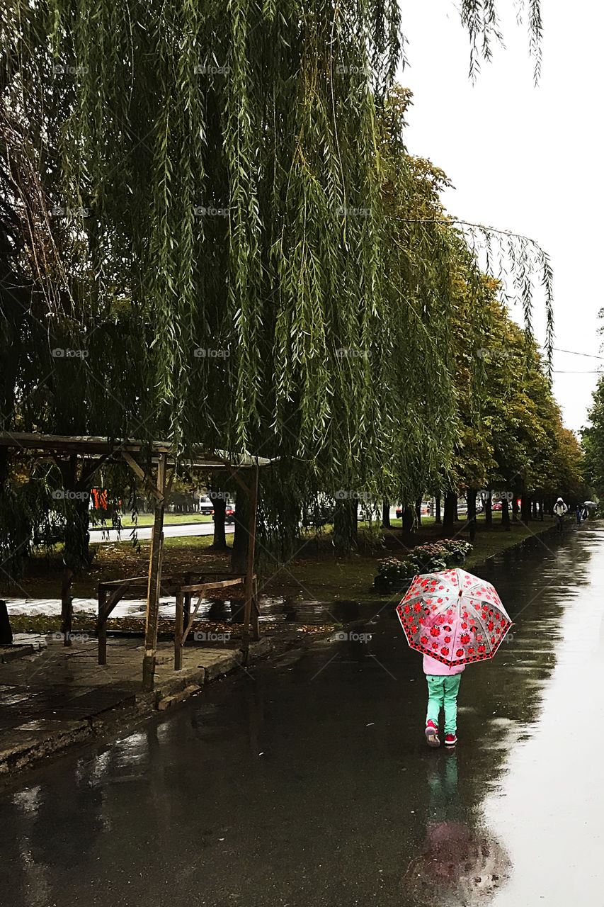 Girl with red umbrella under the rain 