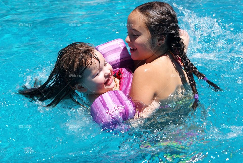 Sisters having fun in swimming pool