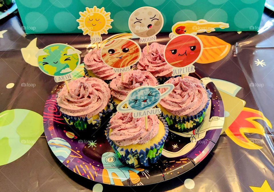 Lemon cupcakes with blueberry frosting and planetary decorations