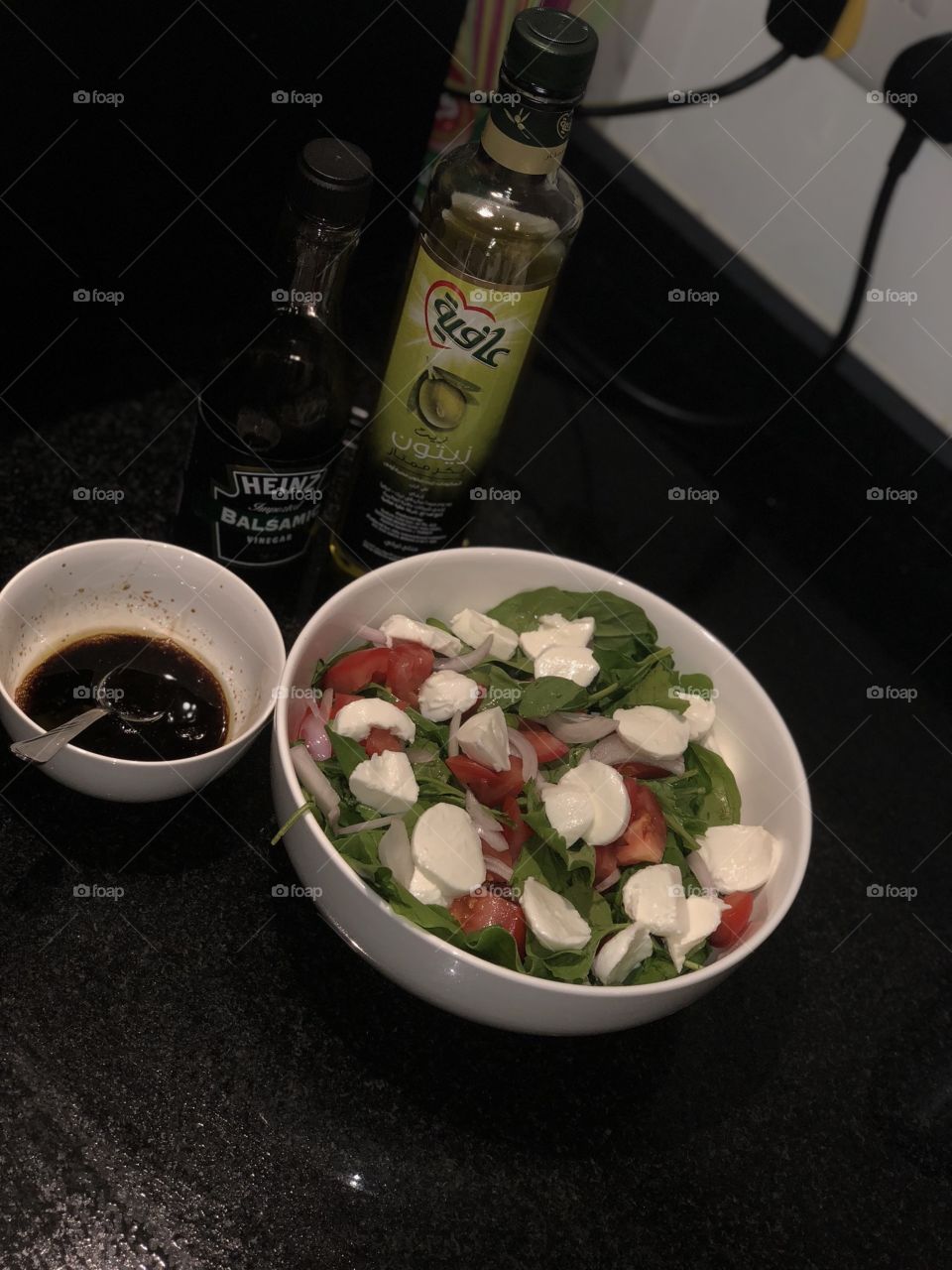 Home-made salad. Fresh mozzarella with Rocca, tomatoes, sliced onions and balsamic vinegar with extra-virgin olive oil