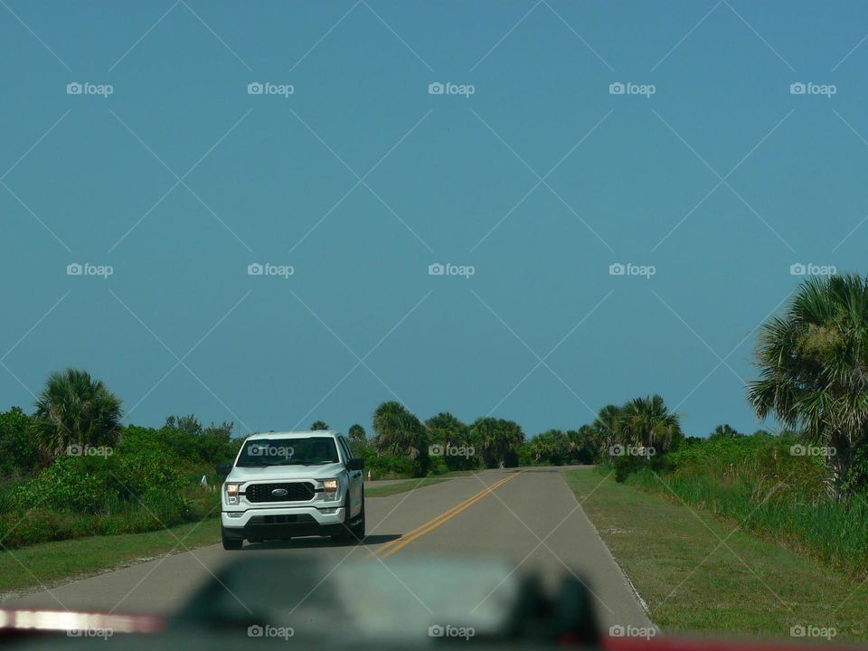 Road trip coming back from the beach in central eastern Florida by the Atlantic Ocean seeing vehicles on the opposite side of the road.