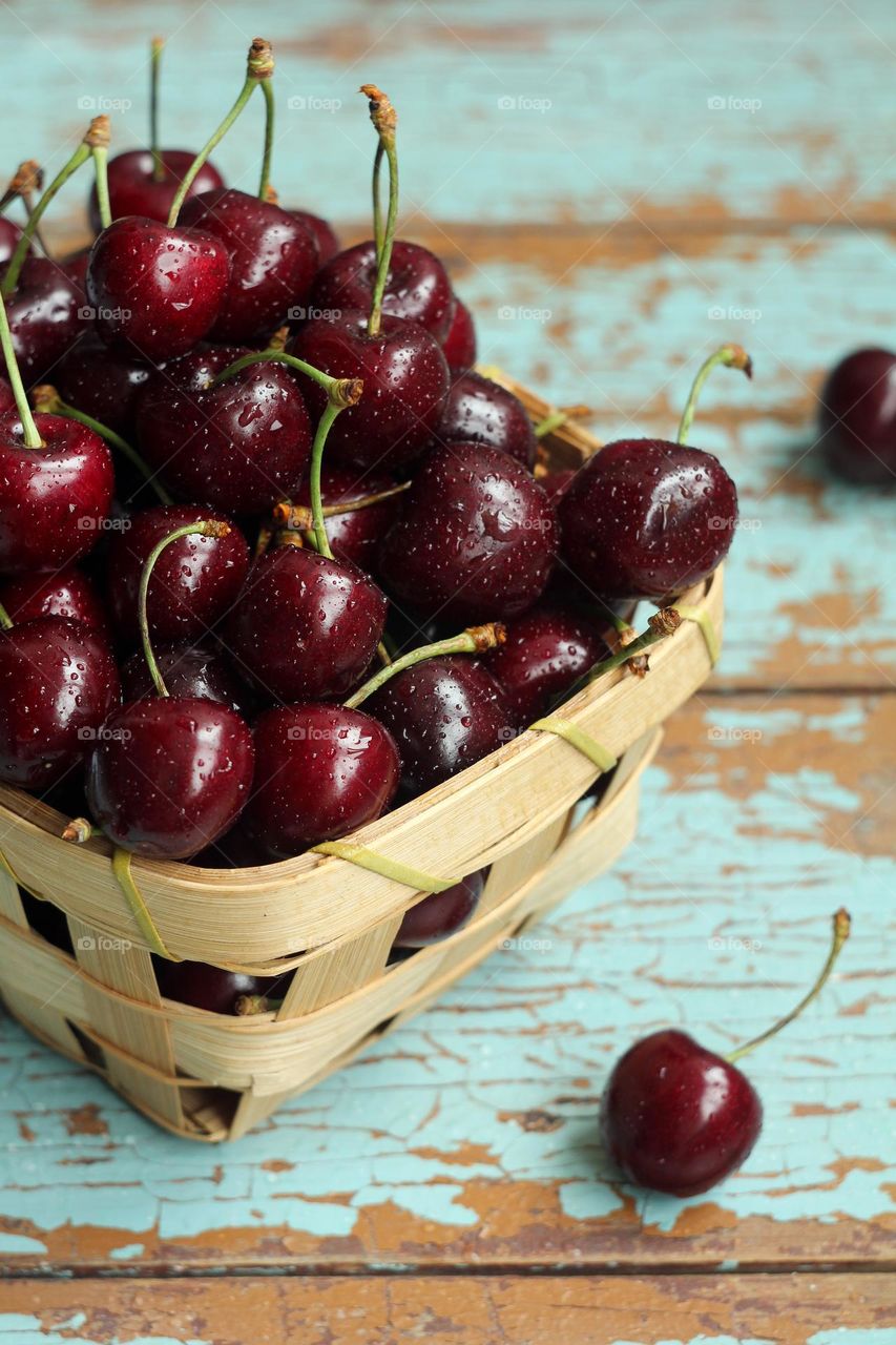 Sweet cherries in a basket on a wooden table