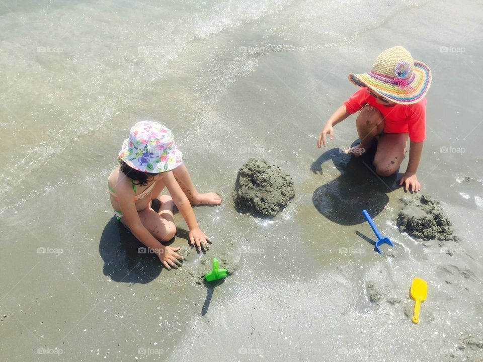 Children playing with sand at beach
