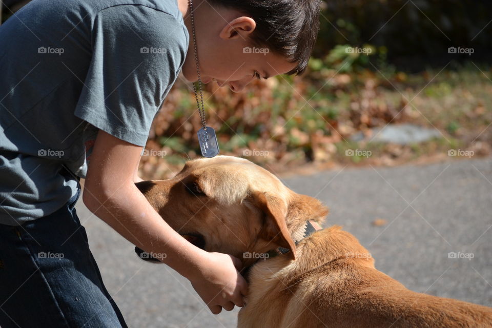 Boy playing with dog on street