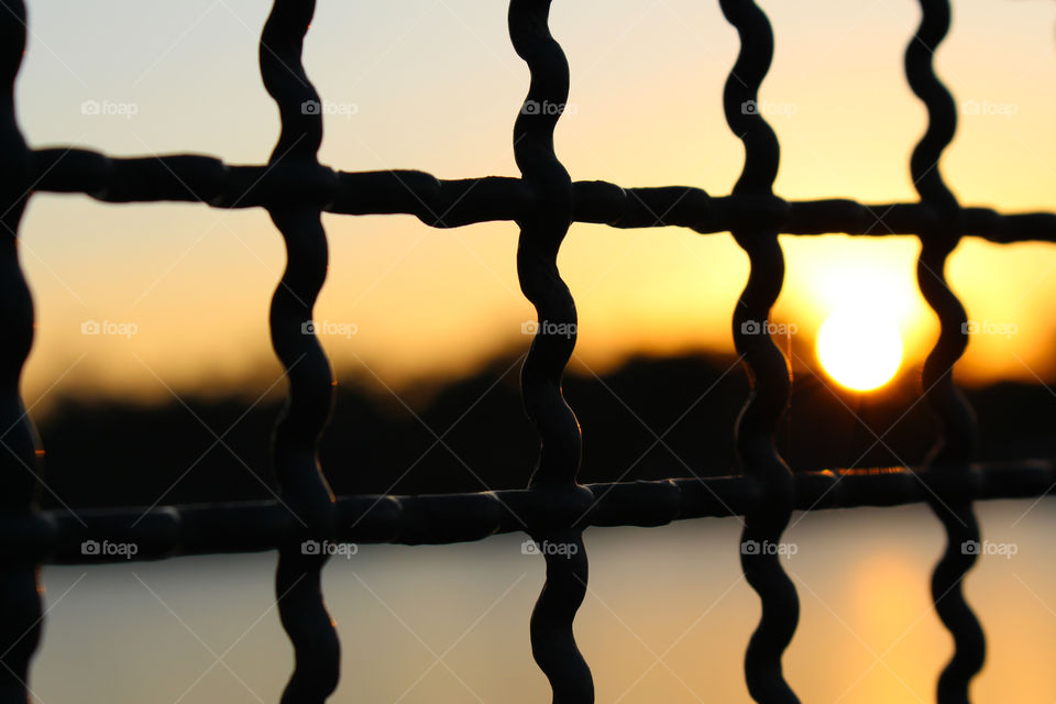 Sun framed in the iron fence