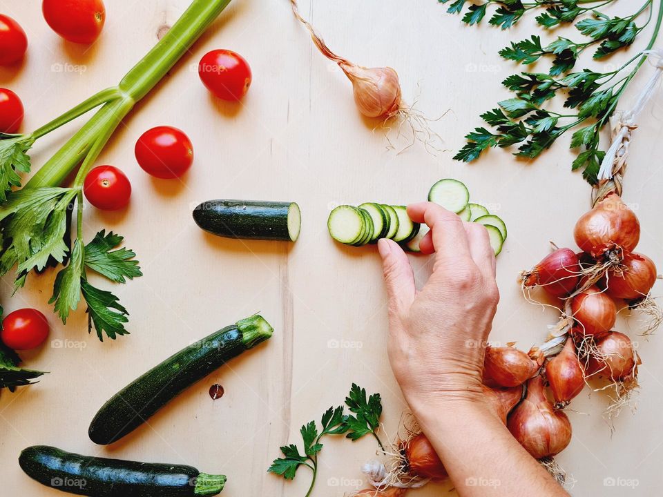 hand on cutting board full of vegetables and healthy food