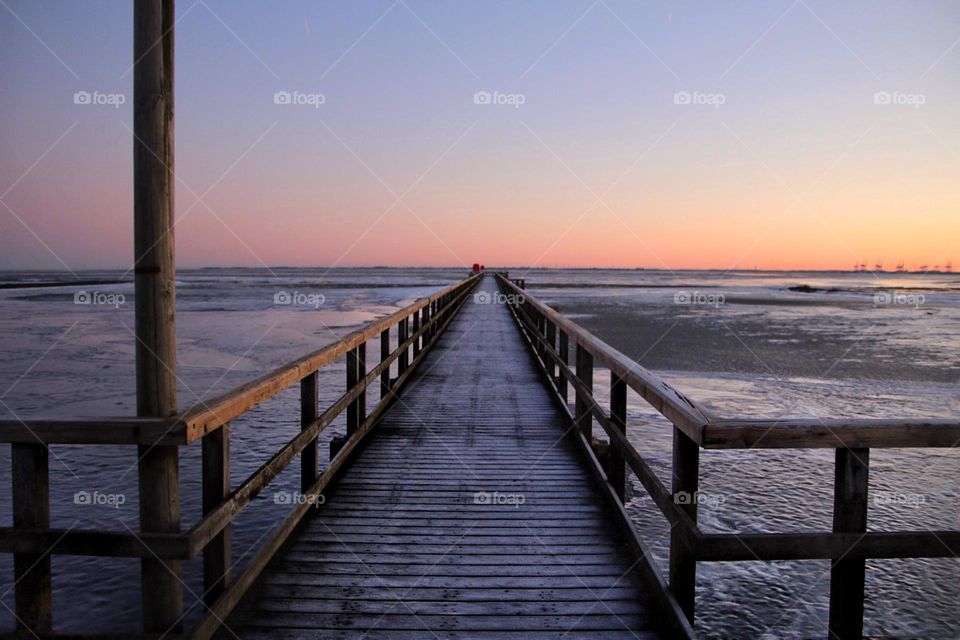 Sunrise in winter on a jetty on the frozen North Sea